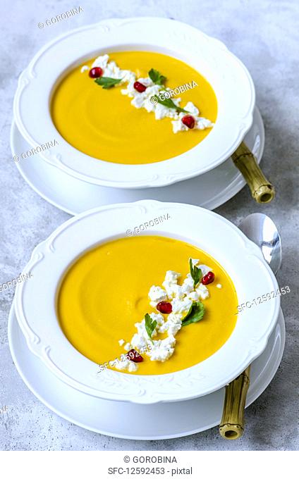 Pumpkin cream soup with feta, parsley and pomegranate seeds