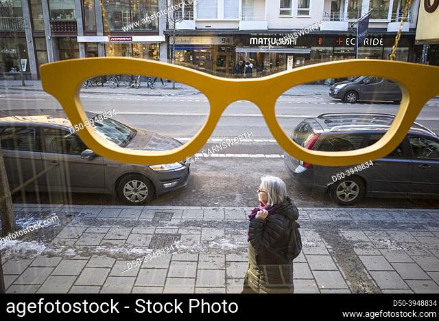 Stockholm, Sweden A pedestrian walks by the window of an optician store on Hornsgatan