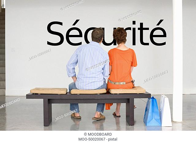 Rear view of couple reading French text sécurité security and contemplating about security
