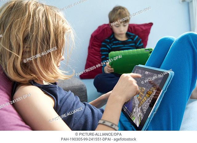 ILLUSTRATION - 02 March 2019, Hamburg: Philip (l) and Mingus (both 9) play the open world computer game Minecraft on their Ipads