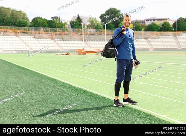 Smiling sportsman standing on sports field