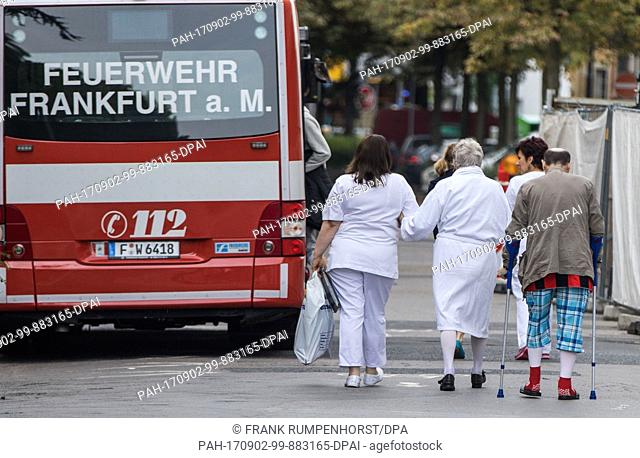 Patients of the Buergerhospital in Frankfurt am Main, Germany, on 02 September 2017, are accompanied to to a large patient transport ambulance (GKTW) in order...