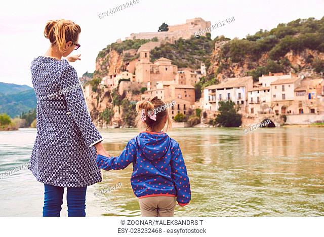 Mother and daughter travellers enjoying view of the Miravet village and Ebro river. Province of Tarragona. Spain