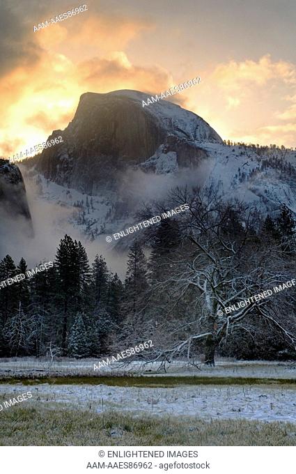 Storm clouds at sunrise and fresh snow in meadow below Half Dome, Yosemite Valley, Yosemite National Park, California