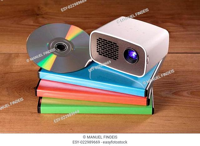 Mini Beamer mit DVD und DVD-Hüllen auf Holztisch