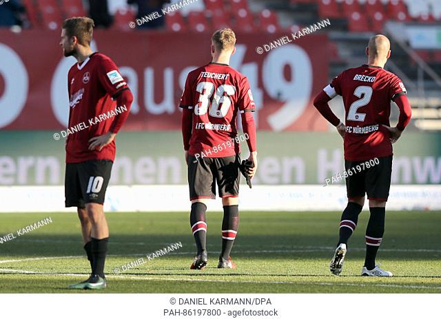 Nuernberg's Tobias Kempe, Cedric Teuchert and Miso Brecko standing on the pitch after the whistle of the German Bundesliga seconds match on the 15th match day...