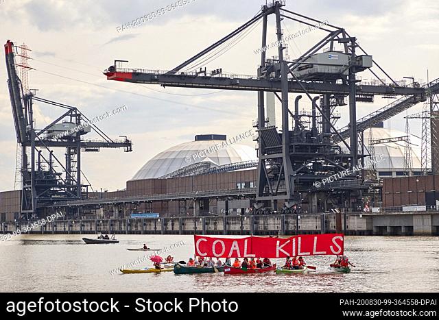 30 August 2020, Hamburg: Climate activists demonstrate in canoes in front of the Moorburg coal-fired power plant on the Elbe river for the immediate shutdown of...