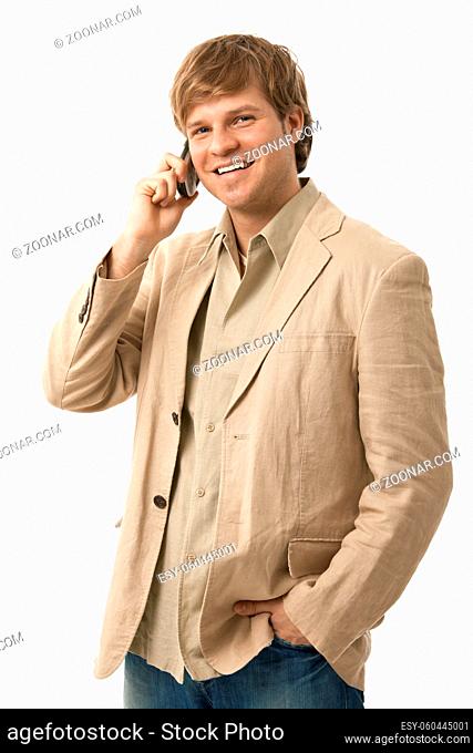 Portrait of casual young man talking on mobile phone, smiling. Isolated on white