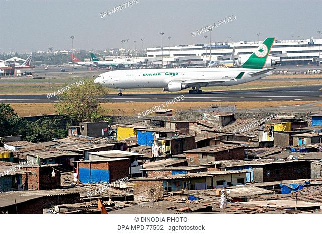 An Air India plane standing at the Chhatrapati Shivaji International Airport terminal while Eva Air Cargo flight taking off from the runaway of the Bombay now...