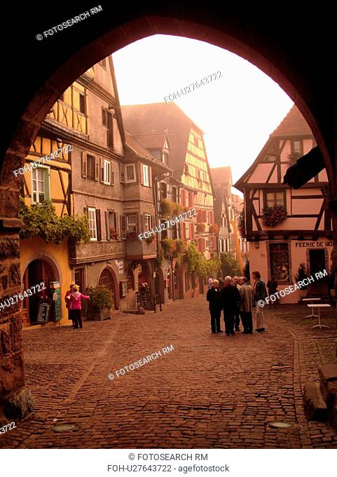 France, Europe, Alsace, Riquewihr, Haut-Rhin, L'Alsace Wine Region, Route du Vin, downtown, archway, cobblestone pedestrian street, half-timbered buildings