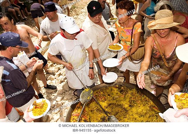 Portions of a giant Paella being served to hungry people in Altea, Costa Blanca, Spain, Europe