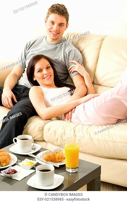 Lovely couple lying on couch in pajamas