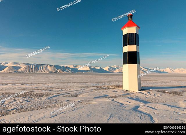 Kapp Ekholm Lighthouse stands in Billefjorden, Spitsbergen on Svalbard. Winter landscape with snow, ice and sunshine