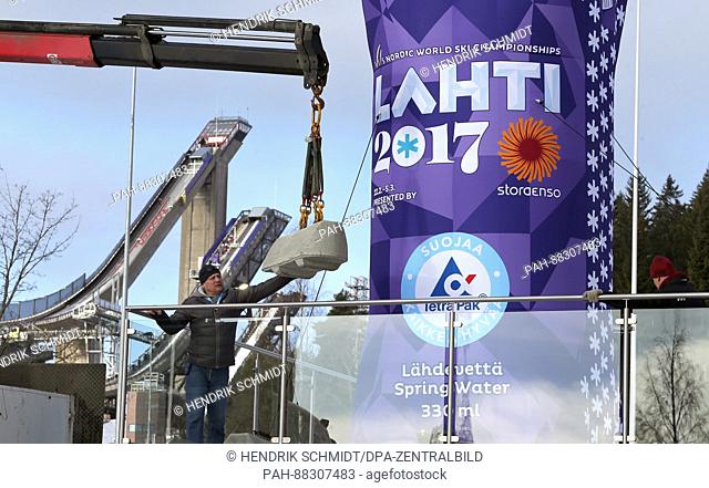 Workers mount attachments for advertisements ahead of the Nordic World Ski Championships in Lahti, Finland, 21 February 2017