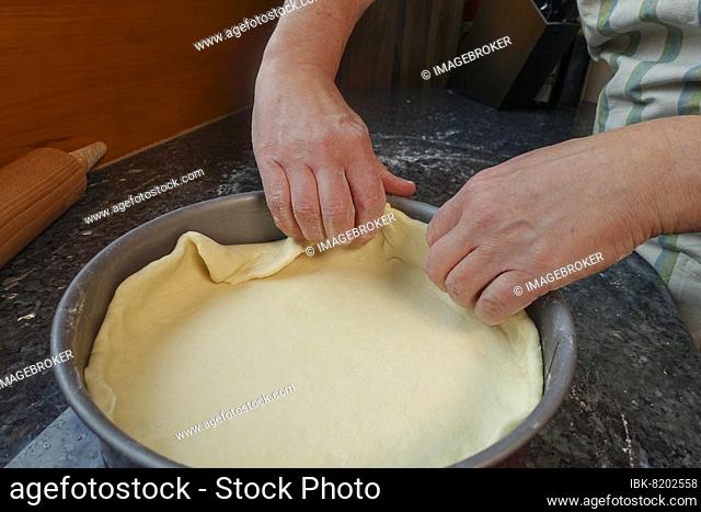 Swabian cuisine, preparation of Härtsfelder potato cake, put curd dough into baking tin, springform pan, cake tray, rolling pin, savoury cake, bake