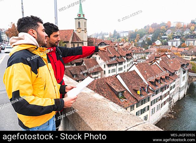 Man pointing by friend holding map at Bern Canton, Switzerland