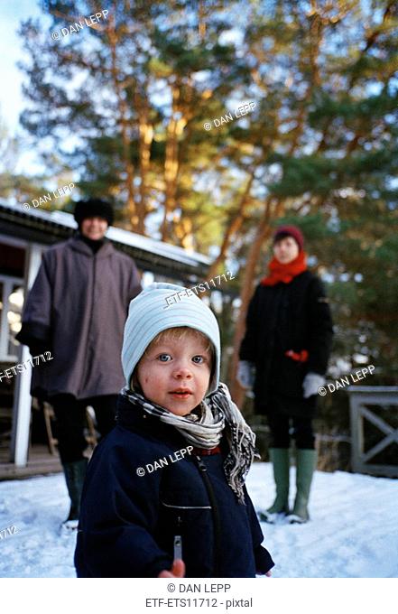 A little boy with his grandmother and mother in the snow Sweden