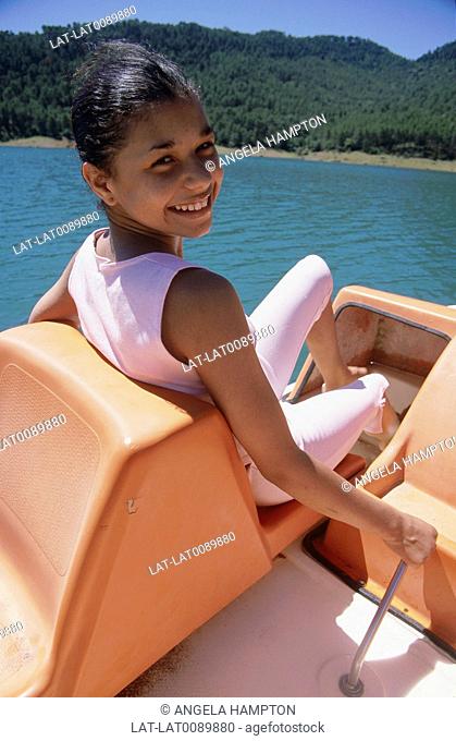 Sierra de Seguras. Young girl turning head to smile. Lake. Pedallo boat