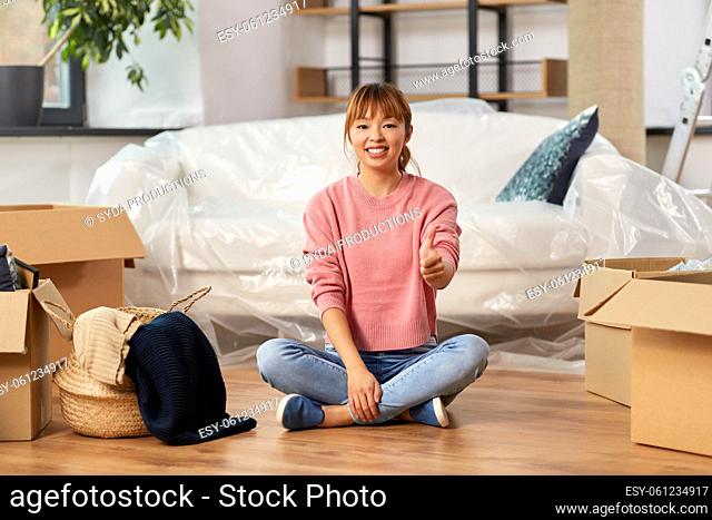 woman moving to new home and showing thumbs up