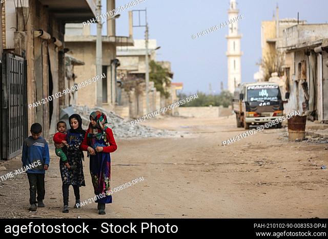 02 January 2021, Syria, Afes: Syrian children wade through a street at the village of Afes. Residents of Afes started returning back to their homes after they...
