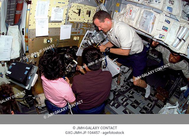 Astronaut David M. Brown (right), STS-107 mission specialist, photographs some science research as astronaut Kalpana Chawla (left), mission specialist