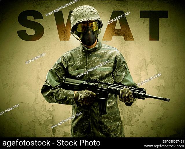 Uniformed armed soldier with damaged wall background