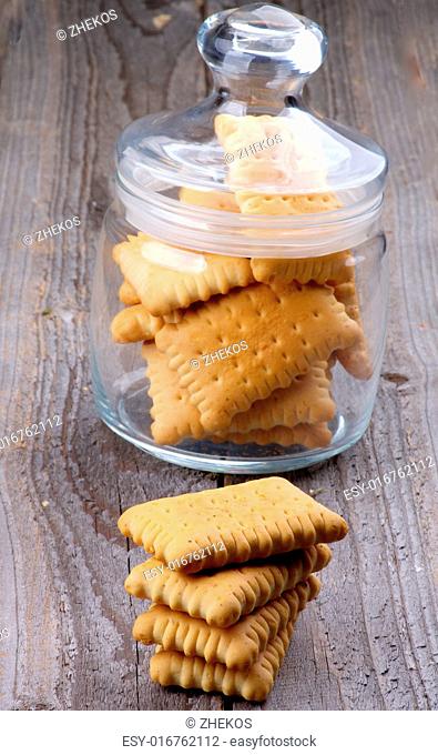 Stack and Glass Jar with Butter Cookies closeup on Rustic Wooden background
