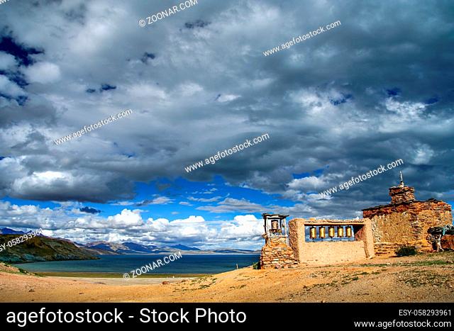 Small old Tibetan monastery and praying mills on a hill above holy Lake Manasarovar Tibet