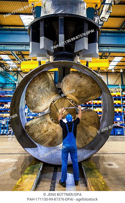 An employee of the Schottel marine propulsion manufacturers working on a rudder propeller at the company's workshop in Wismar, Germany, 30 November 2017