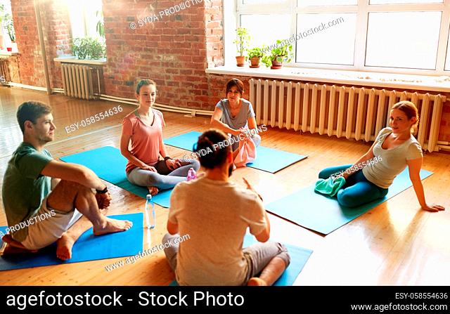 group of people resting on yoga mats at studio