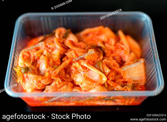 Korean Food Kimchi Served in Plastic Container Horizontal Shot Against Black Background