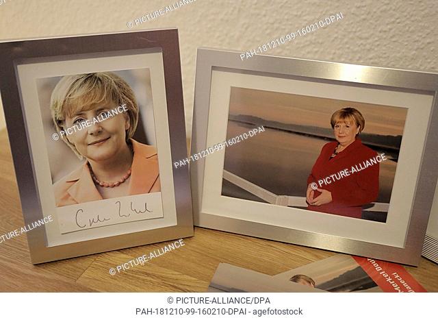 30 November 2018, North Rhine-Westphalia, Attendorn: A photo of Ursula Wanecki (r), Merkel Double, is standing in her apartment next to an autograph card of the...