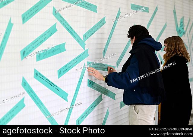 27 January 2023, Brandenburg, Oranienburg: Employees of the memorial stick labeled adhesive tapes on the wall in the interior of ""Station Z"" of the...