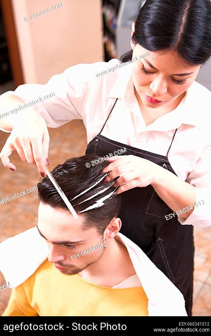 Products of professional cosmetics. Closeup picture of hairdresser making handsome man#39;s man with style in hairdressing saloon