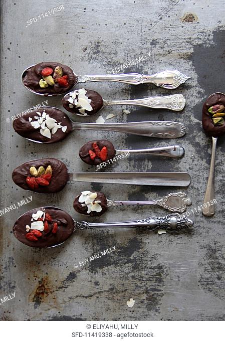 Spoons of chocolate, goaded berries and nuts