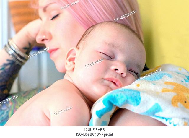Woman asleep with sleeping baby boy on shoulder