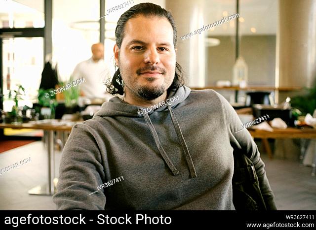Satisfied man sitting in a restaurant with buffet. Brunch, breakfast and dining choice concept