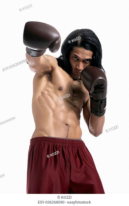 Portrait of confident male boxer in punching stance against white background