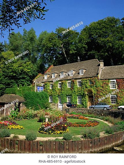 The Swan Hotel and garden full of summer flowers at Bibury, in the Cotswolds, Gloucestershire, England, United Kingdom, Europe