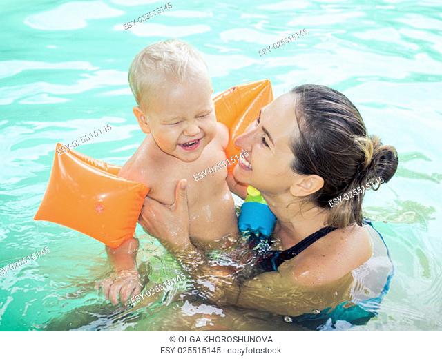 Baby and mother in swimming pool