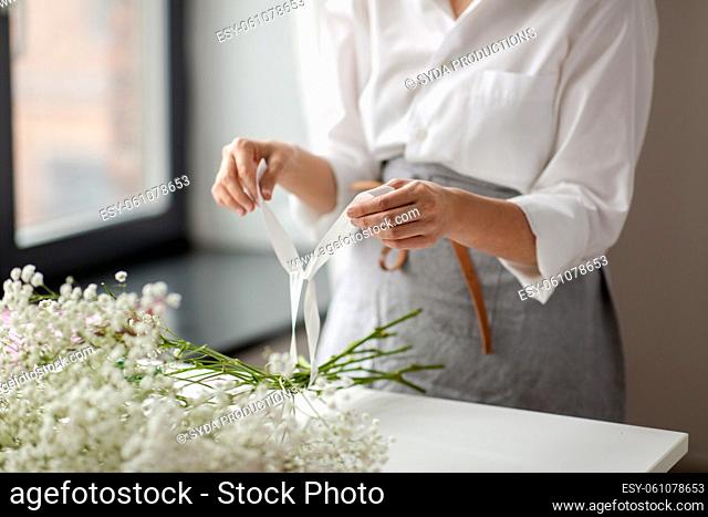 woman or floral artist making flower bunch