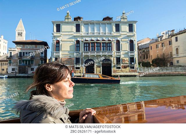 Woman travel in a taxi boat on Grand Canal in Venice, Italy