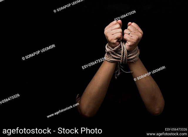 Slave Asian woman fears she was hands tied up with rope black background. Stop violence against kidnap trafficking, International Human Rights day