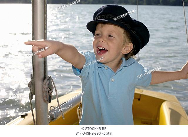 Little boy in a plastic boat is pointing at something, close-up