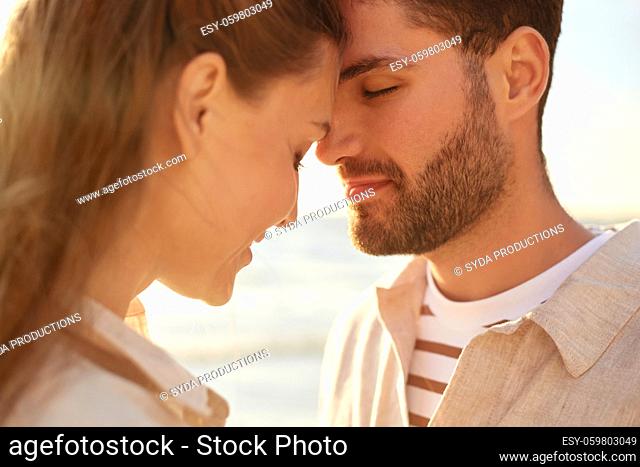 happy couple with closed eyes on summer beach