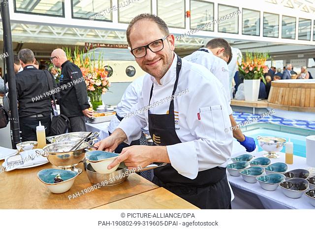 02 August 2019, Hamburg: Rolf Fliegauf, top chef, served during the gourmet event ""Europe's best"" on the luxury ship MS Europa Kingfisch with posed oyster...