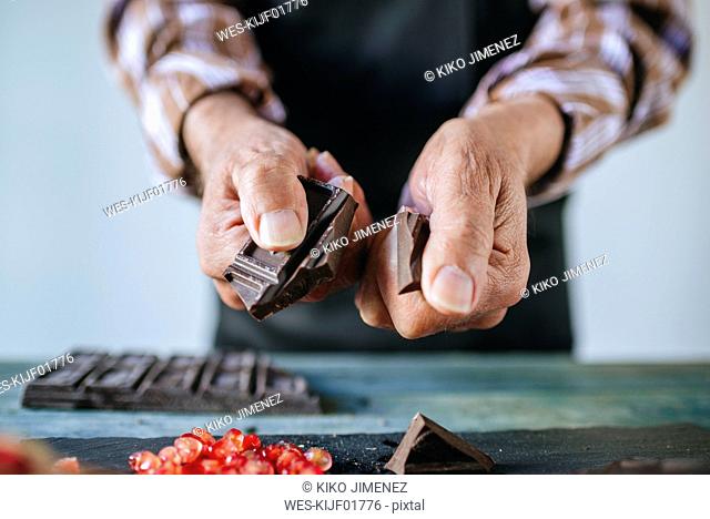Man's hands breaking a chocolate bar, close-up