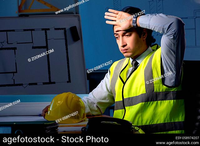 Young construction architect working on project at night