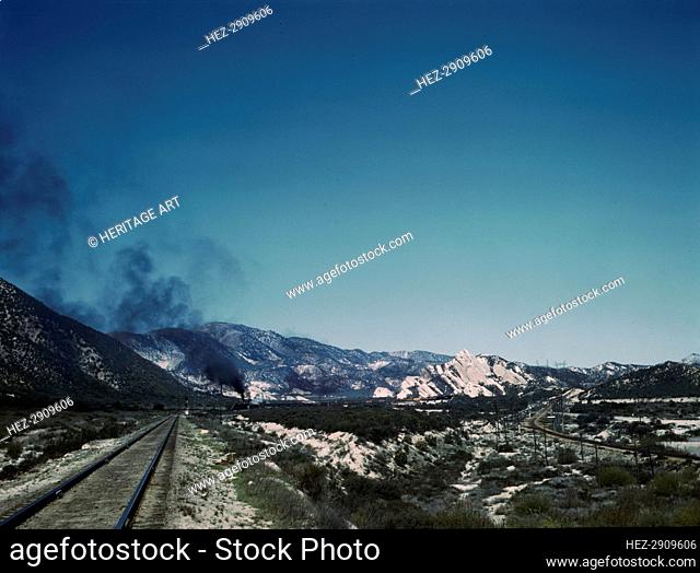 Freight train going up Cajon Pass through the San Bernardino Mountains, Cajon, Calif., 1943. Creator: Jack Delano