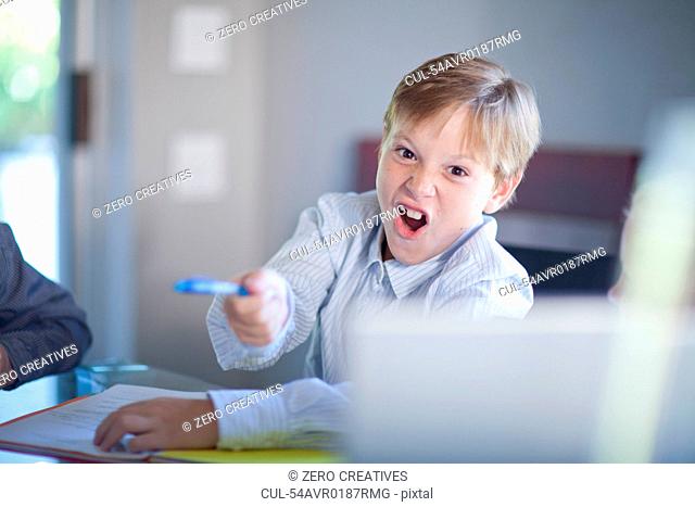 Boy playing businessman at desk